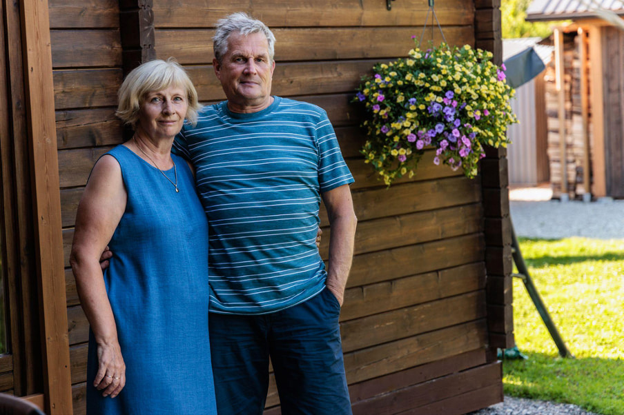 Ægteparret foran deres saunahytte i haven